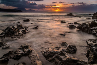 View of calm beach at sunset