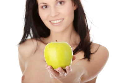 Close-up of woman holding apple against white background