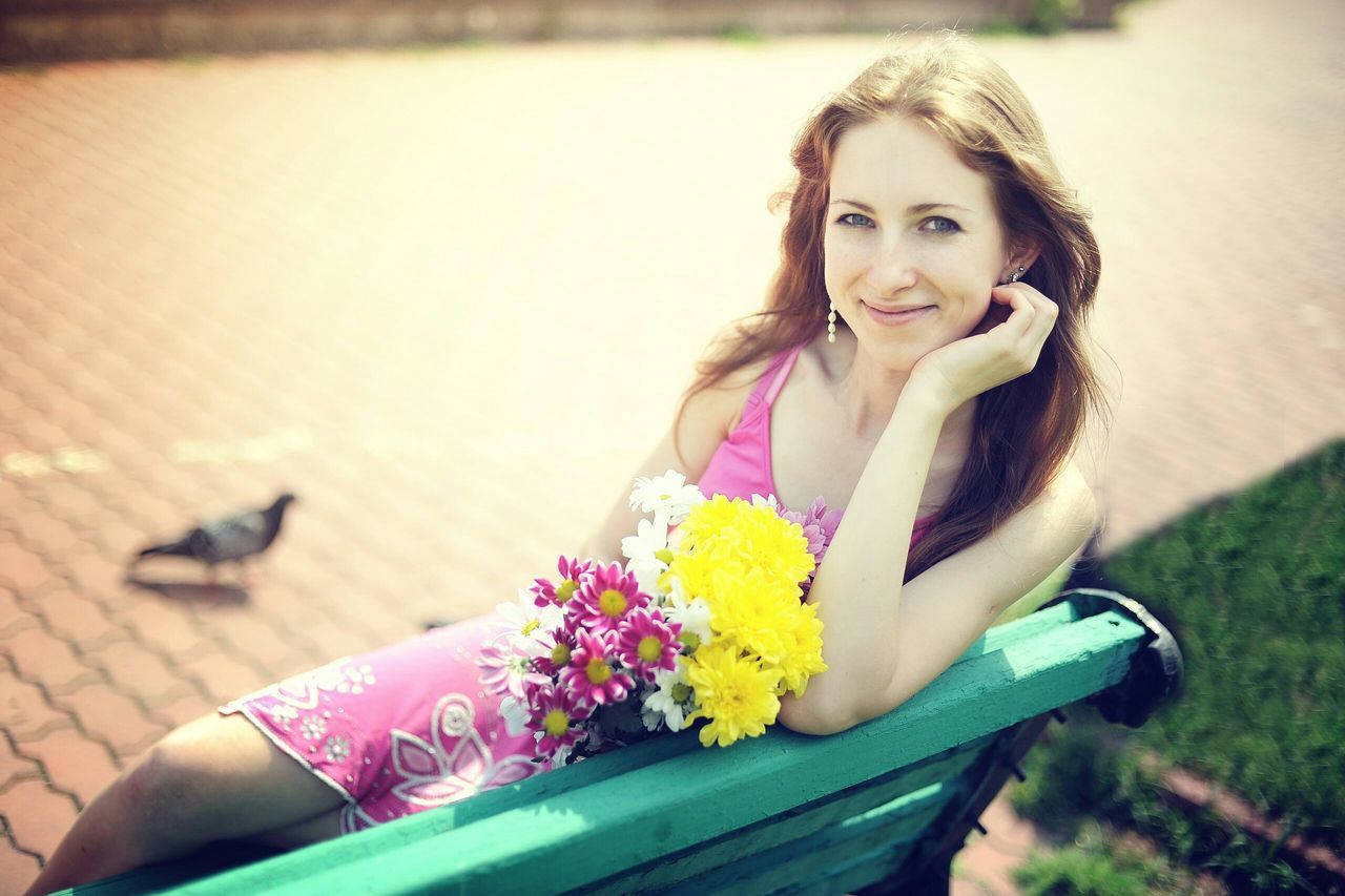 person, portrait, lifestyles, looking at camera, leisure activity, casual clothing, young adult, smiling, flower, young women, focus on foreground, front view, happiness, sitting, childhood, elementary age, waist up, girls