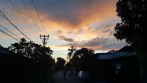 Silhouette of trees against cloudy sky