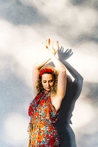 Portrait of woman standing against wall