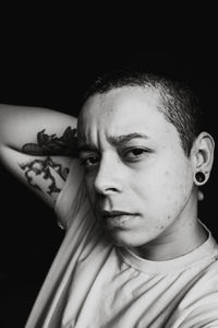 Close-up portrait of young man against black background