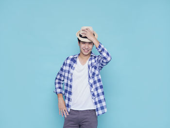 Portrait of man standing against blue background
