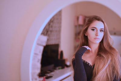 Portrait of beautiful young woman in mirror at home
