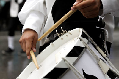 Midsection of musician playing drum