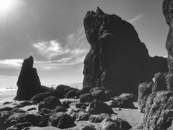 Low angle view of rock formation at beach against sky