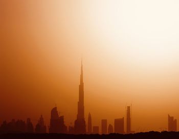 Silhouette of buildings against sky during sunset
