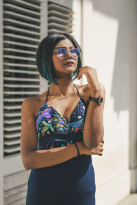 Young woman standing against wall