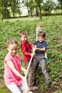 Happy siblings and plants against trees