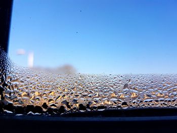 Close-up of frozen water against sky