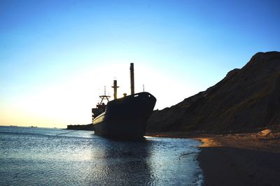 Ship moored on sea against sky during sunset