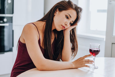 Beautiful young woman sitting at home