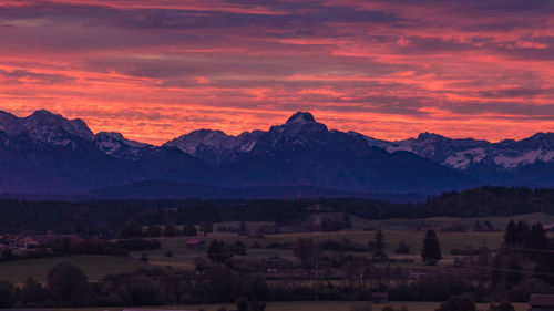 Scenic view of silhouette mountains against orange sky