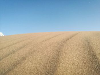 Scenic view of desert against clear blue sky