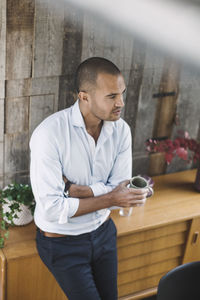 High angle view of businessman holding coffee cup while standing in portable office truck