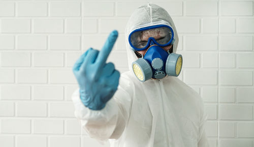 Portrait of man holding camera on wall