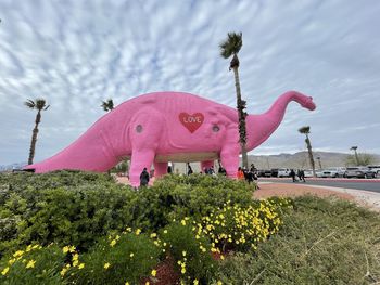 Statue of pink flowering plants against sky