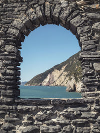 Arched window in the ancient walls with a beautiful panorama of the coast