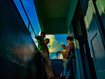 Low angle view of people standing on bridge