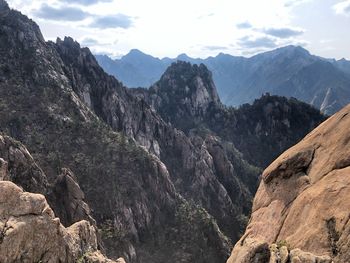 Scenic view of mountains against cloudy sky