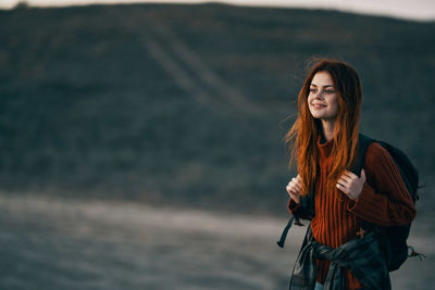 Portrait of smiling young woman standing outdoors