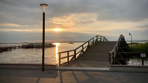 Pier over sea against sky during sunset