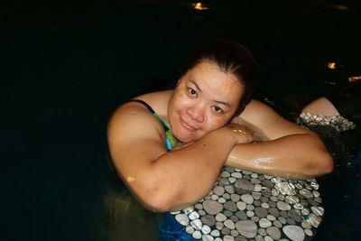 Portrait of woman in swimming pool at night