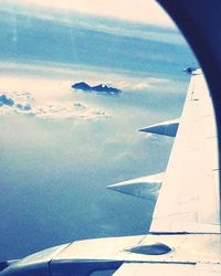 Cropped image of airplane flying over sea