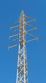 Electricity pylon against clear blue sky