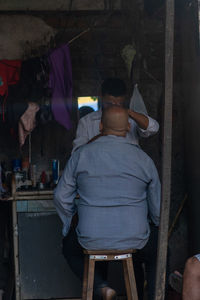 Rear view of man standing against graffiti