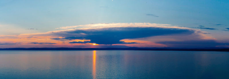 Scenic view of sea against dramatic sky during sunset