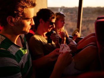 People playing cards while sitting in bus