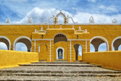 Low angle view of yellow building against sky