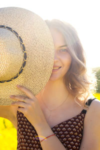 Portrait of a girl, holding in her hands, vertical, collaboration, half face, straw hat, rural life