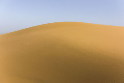 Sand dunes in desert against clear sky