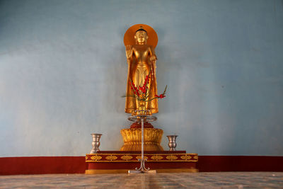 Statue of buddha against wall in building