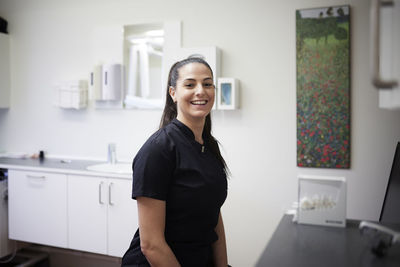 Female dentist standing in office