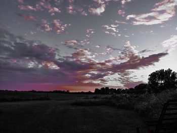 Scenic view of silhouette field against sky at sunset