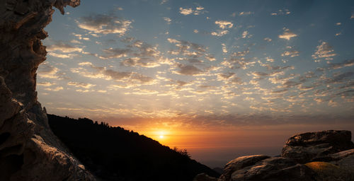 Silhouette rock formation against sky during sunset