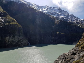 Scenic view of lake by mountains against sky