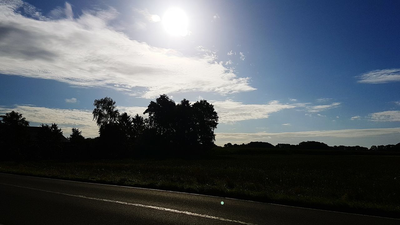 silhouette, tree, road, transportation, sky, sun, landscape, tranquil scene, outline, tranquility, nature, cloud, scenics, beauty in nature, outdoors, day, country road, dark, solitude, cloud - sky, non-urban scene, no people, the way forward, remote