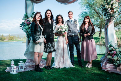 Portrait of friends standing against plants