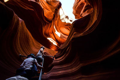 Tourists in cave amidst rock formation