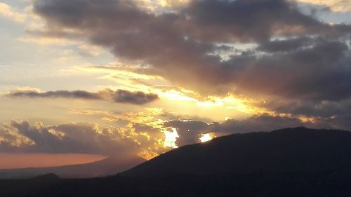 Scenic view of dramatic sky over silhouette landscape