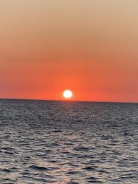 Scenic view of sea against orange sky