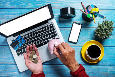 High angle view of hand holding coffee cup on table