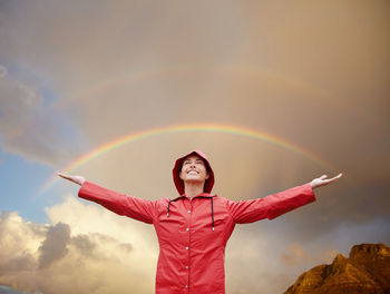 Portrait of young woman standing against sky