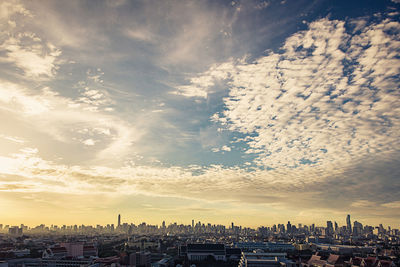 Aerial view of buildings in city against sky