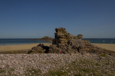 Rock formation on beach against clear sky