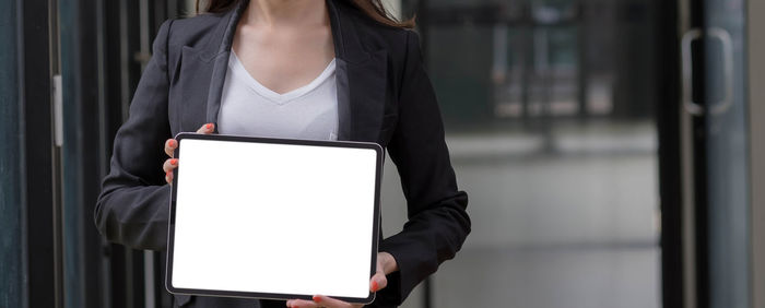 Midsection of woman holding mobile phone